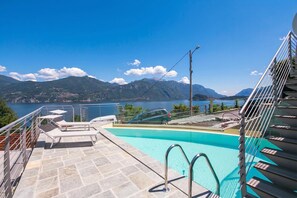 Una piscina con vistas a montañas y un coche aparcado cerca.