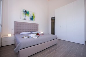 A modern bedroom with a large bed, a nightstand, a bedside table, and a wardrobe. - Paradiso di Menaggio Penthouse (Menaggio)