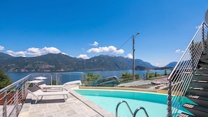 Piscina com vista para montanhas e um carro estacionado perto.