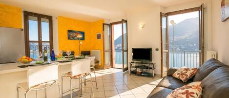 A modern living space with a kitchen, dining area, and a sofa with a view.