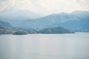 A lake surrounded by mountains with a small island in the center.