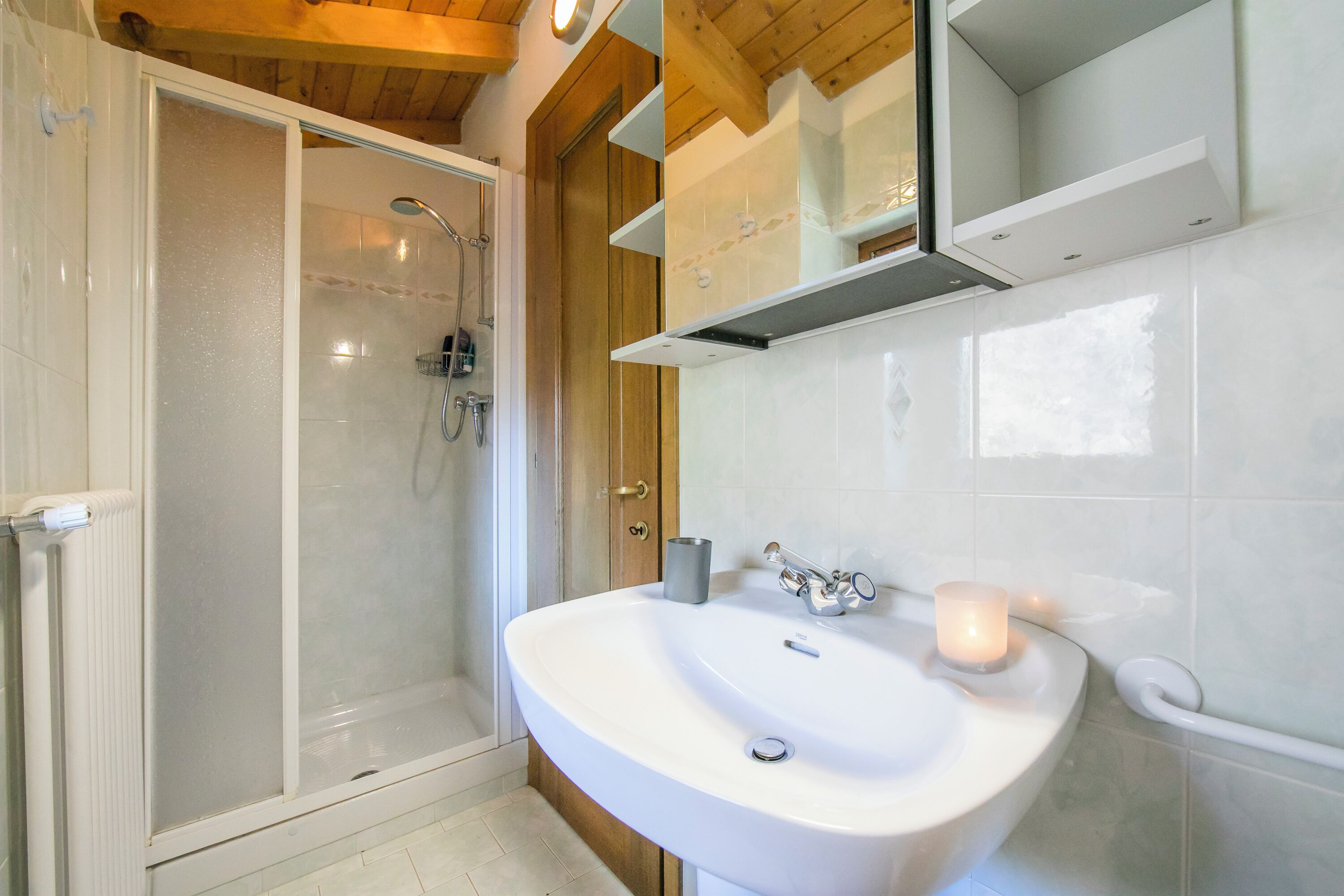 A bathroom with a shower, sink, and mirror.