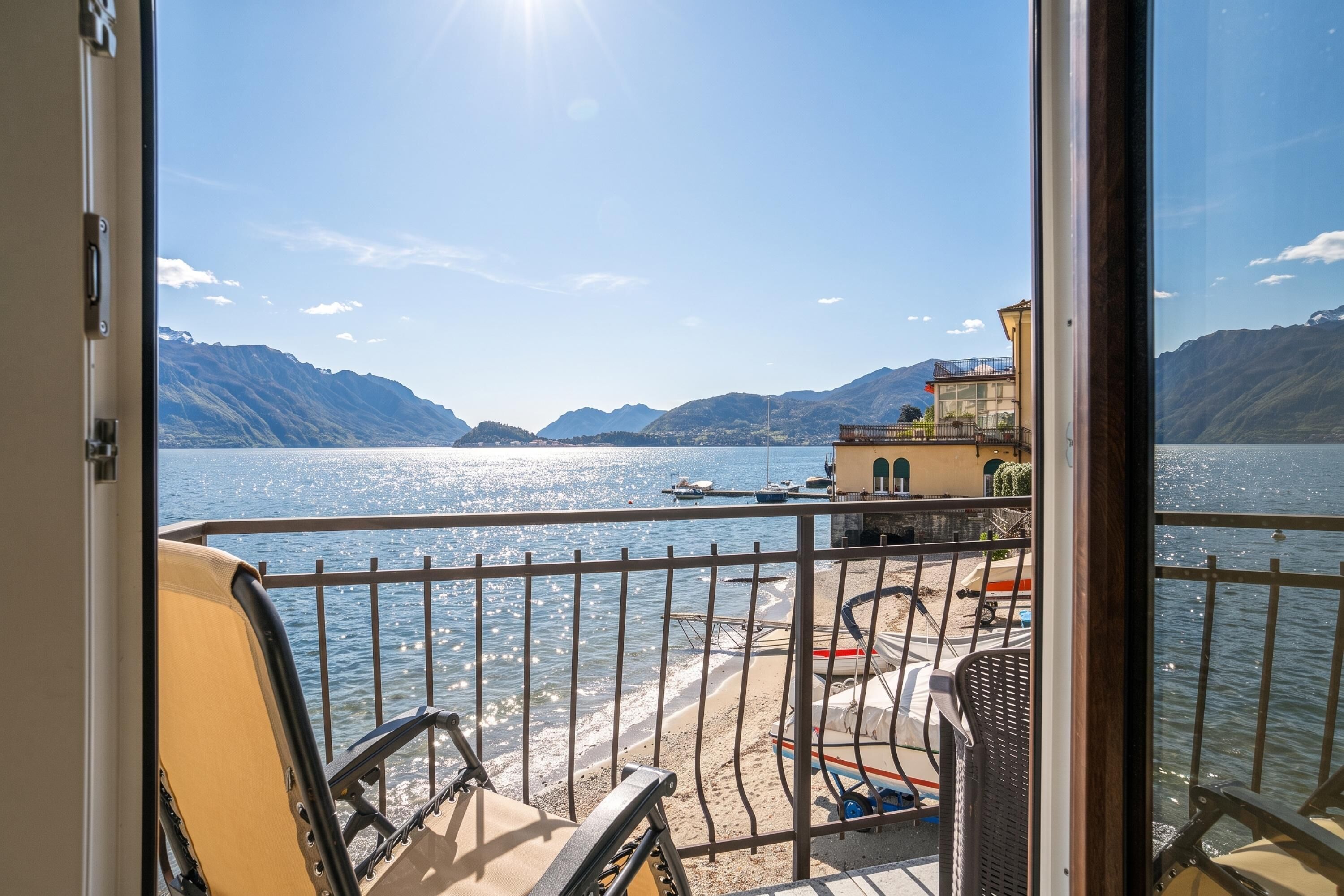 A balcony with a view of a lake, mountains, and boats.