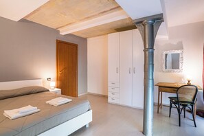 Quarto com cama, escrivaninha, cadeira, guarda-roupa e espelho.