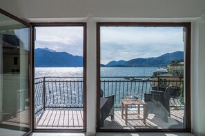 A balcony with a view of a lake and mountains, furnished with chairs and a table. - Menaggio Tosca 2 (Menaggio)