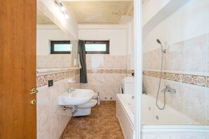 Uma casa de banho com lavatório, sanita e banheira.