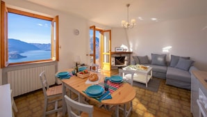Un coin repas avec vue sur les montagnes, un canapé et une cheminée.