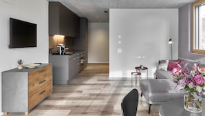 A modern living space with a kitchen, dining area, and seating area. - BoHo by Maier - kontaktloser Check-In (Buchs)