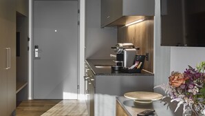 A modern kitchen with a wooden countertop, a built-in oven, and a coffee machine. - BoHo by Maier - kontaktloser Check-In (Buchs)