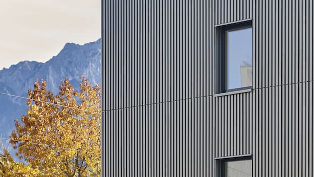 A modern building with vertical siding and a prominent sign. - BoHo by Maier - kontaktloser Check-In (Buchs)