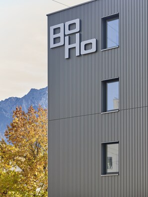 Un edificio moderno con revestimiento vertical y un letrero llamativo.