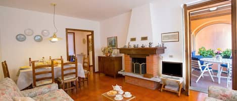 Departamento familiar, varias habitaciones, junto a la montaña (Menaggio Poggio Fiorito Loggetta) | Área de sala de estar | Televisión de 24 pulgadas con canales digitales, chimenea y estéreo