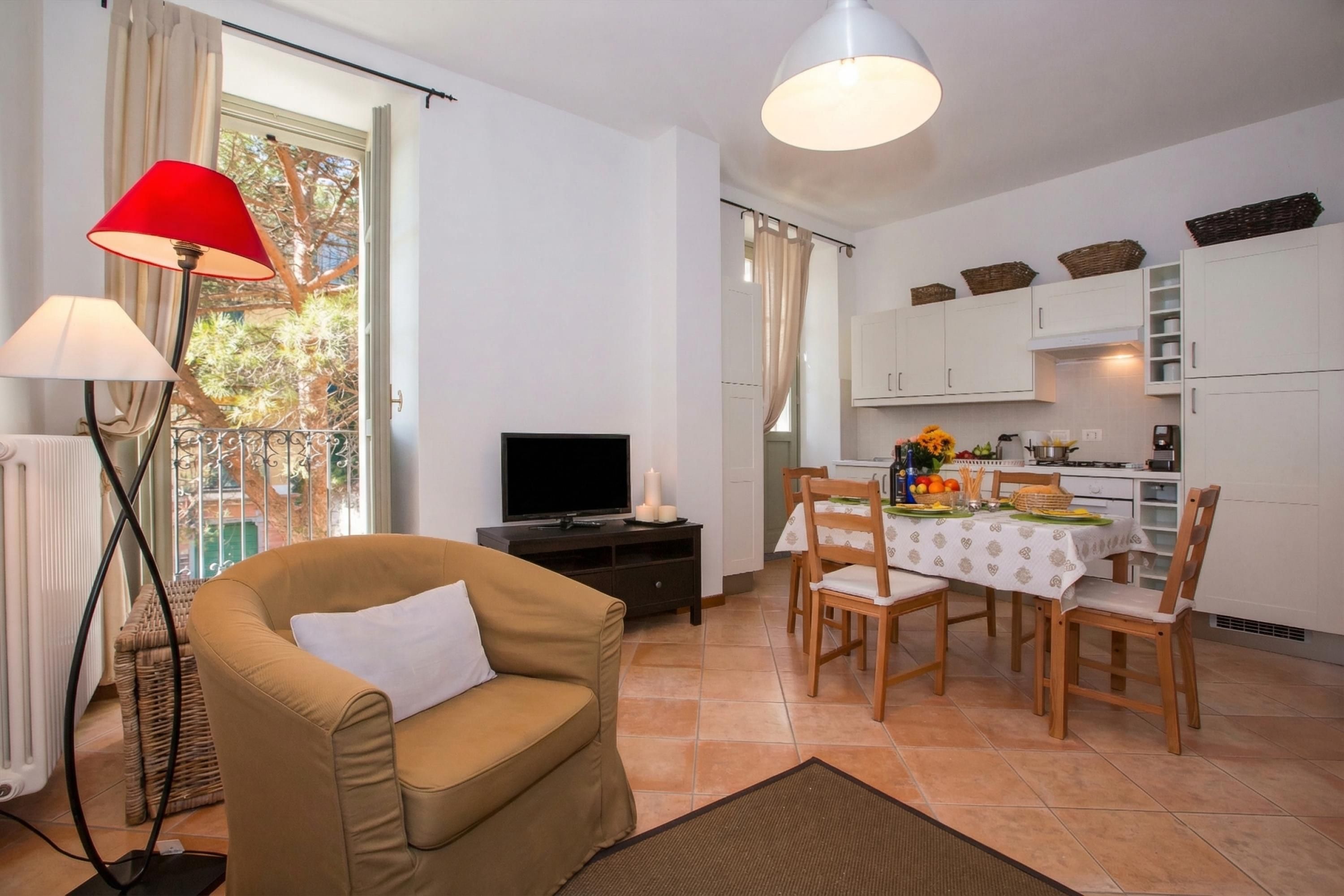 A living room with a sofa, TV, and dining area with a table and chairs.