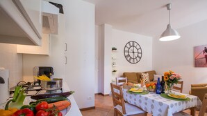 Une cuisine équipée d’une cuisinière, d’un évier et d’un coin repas avec une table mise pour deux personnes.