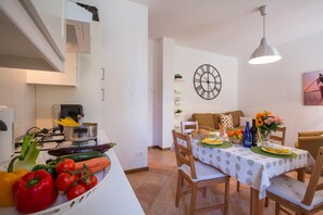 Uma cozinha com fogão, pia e área de jantar com mesa posta para dois.