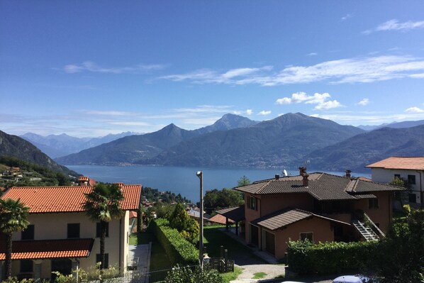 A coastal village with traditional architecture, a clear view of the sea, and mountains in the background. - Villa Rosalia (Menaggio)
