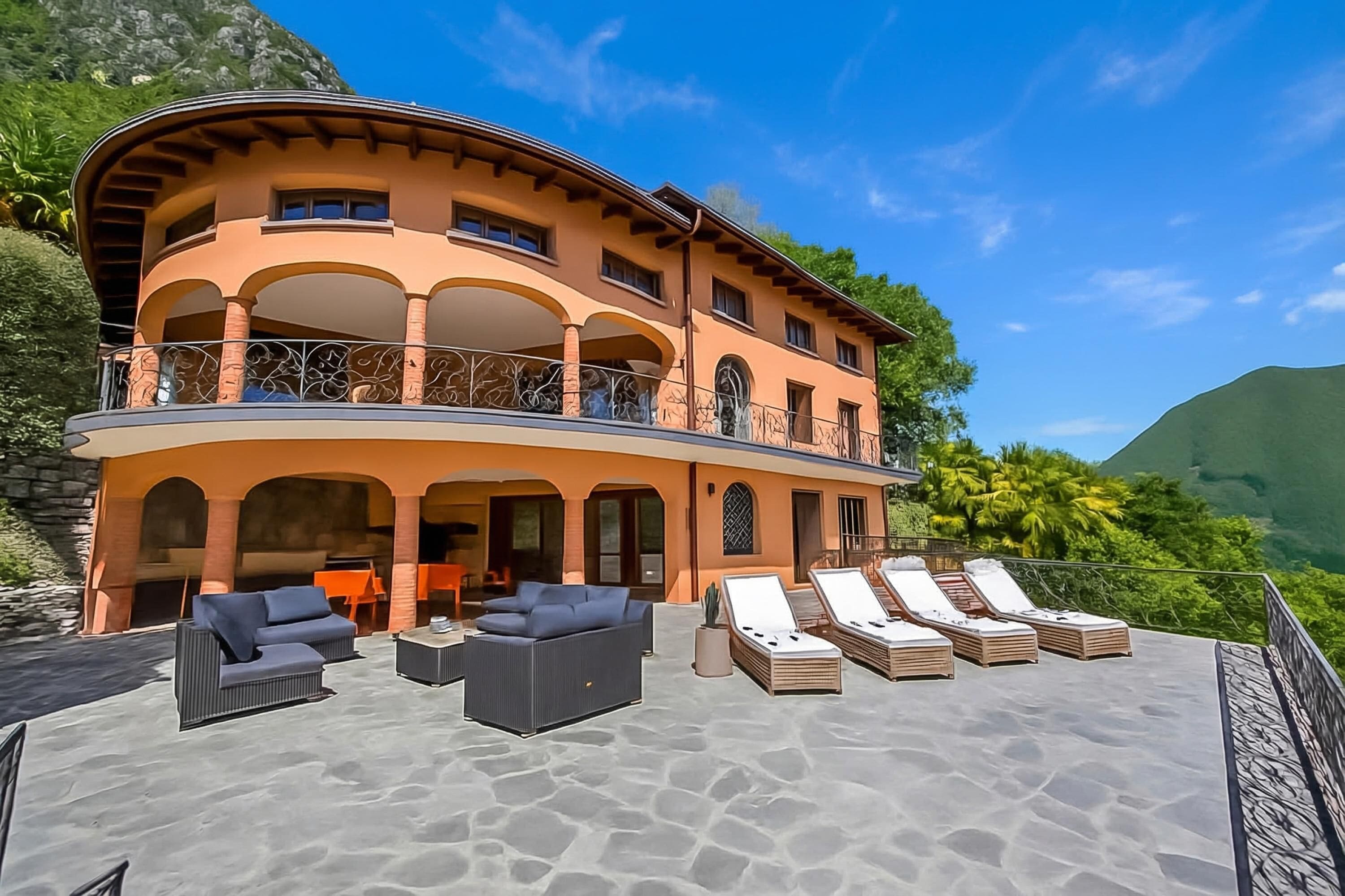 A multi-story building with a curved roof, outdoor seating area, and a balcony.