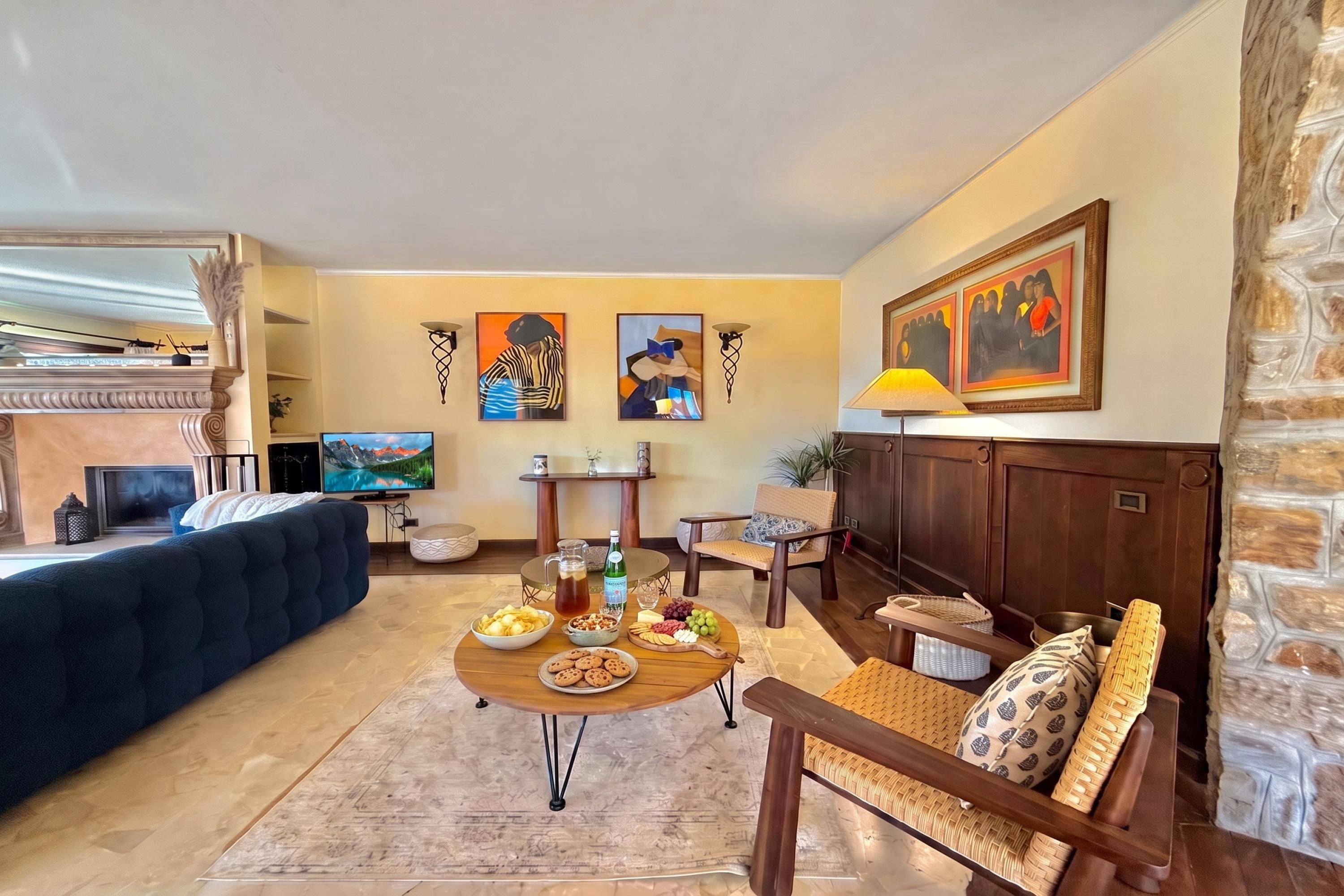Una sala de estar con sofá, mesa de centro y cuadros en la pared.