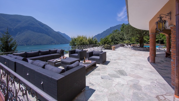 A terrace with outdoor seating, a pool, and a view of mountains and a lake. - Villa Isola Verde (Main Villa) (Valsolda)