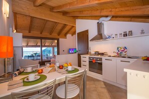 Appartamento familiare, letti multipli, 2 bagni, lato montagna (Borgo La Sorgente - Tulipano) | Cucina privata | Microonde, forno, piano cottura, lavastoviglie