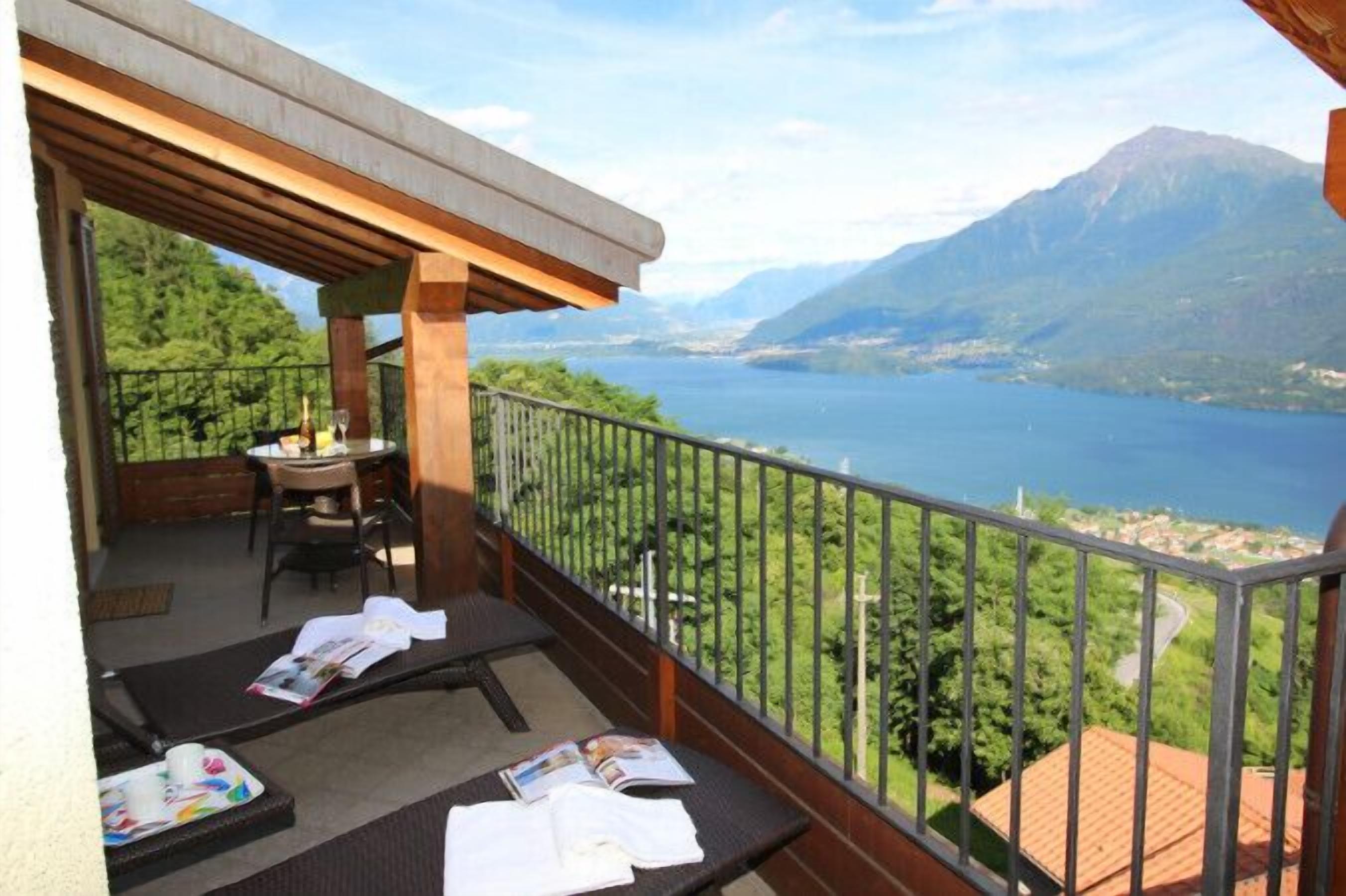 A balcony with a table and chairs, overlooking a lake and mountains. - Borgo La Sorgente - Tulipano (Gravedona)