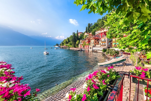 A waterfront hotel with clear lake views, a stone pathway, and colorful buildings.