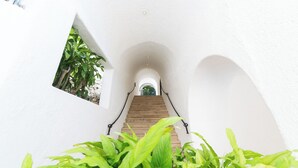 A white-walled staircase with a wooden handrail, leading to an arched doorway at the top. - Beautiful Villa with Pool and Bay Views in Acapulco (Acapulco de Juárez)