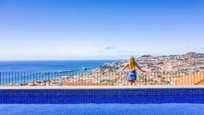 Vista de la piscina con vistas a una ciudad costera y un cielo despejado.