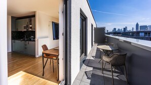 Un appartement moderne doté d’un balcon, d’un coin repas et d’une cuisine.