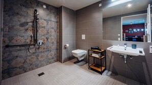 Une salle de bain moderne équipée d’une douche, de toilettes et d’un lavabo.