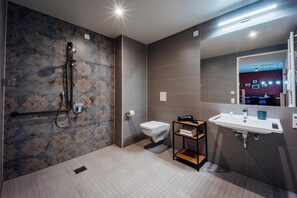 Ein modernes Badezimmer mit Dusche, Toilette und Waschbecken.