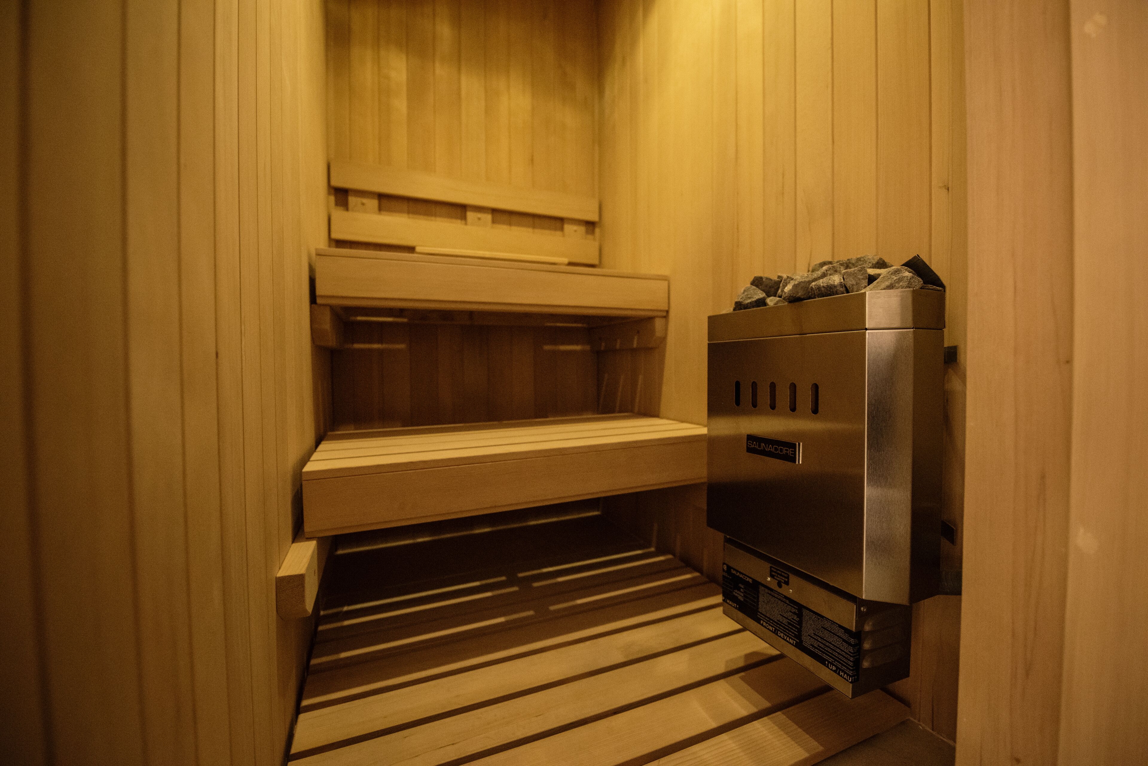 A sauna with wooden benches and a steam generator.