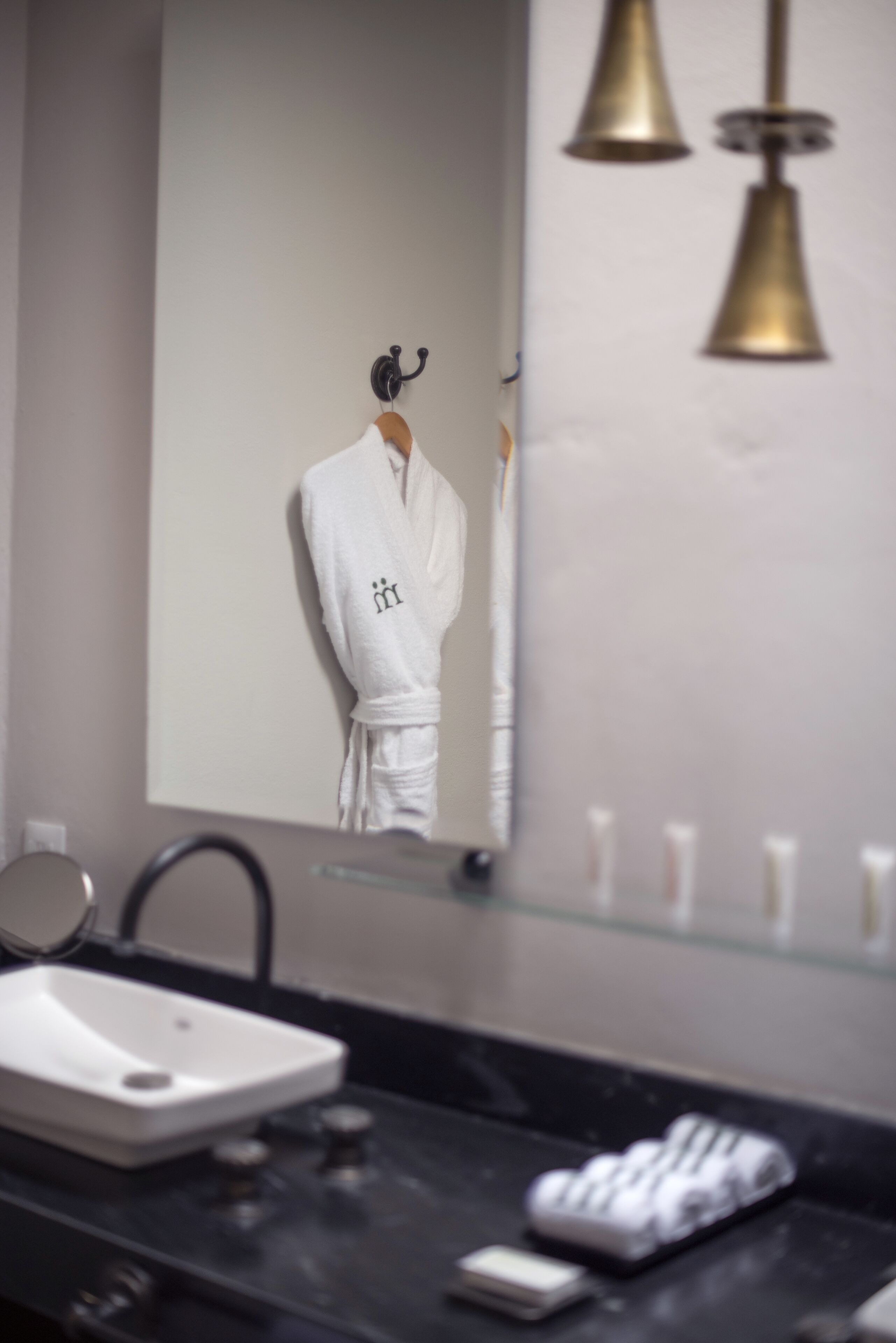 A bathroom with a sink, mirror, and toiletries.