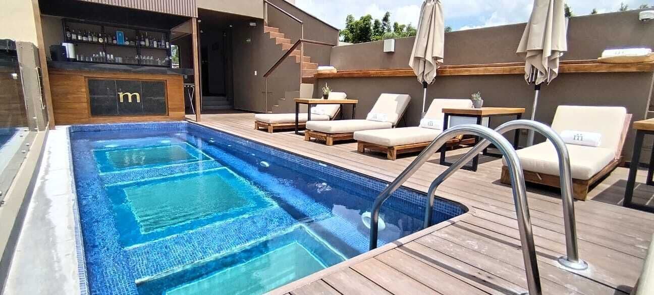 A swimming pool with lounge chairs and a bar area.