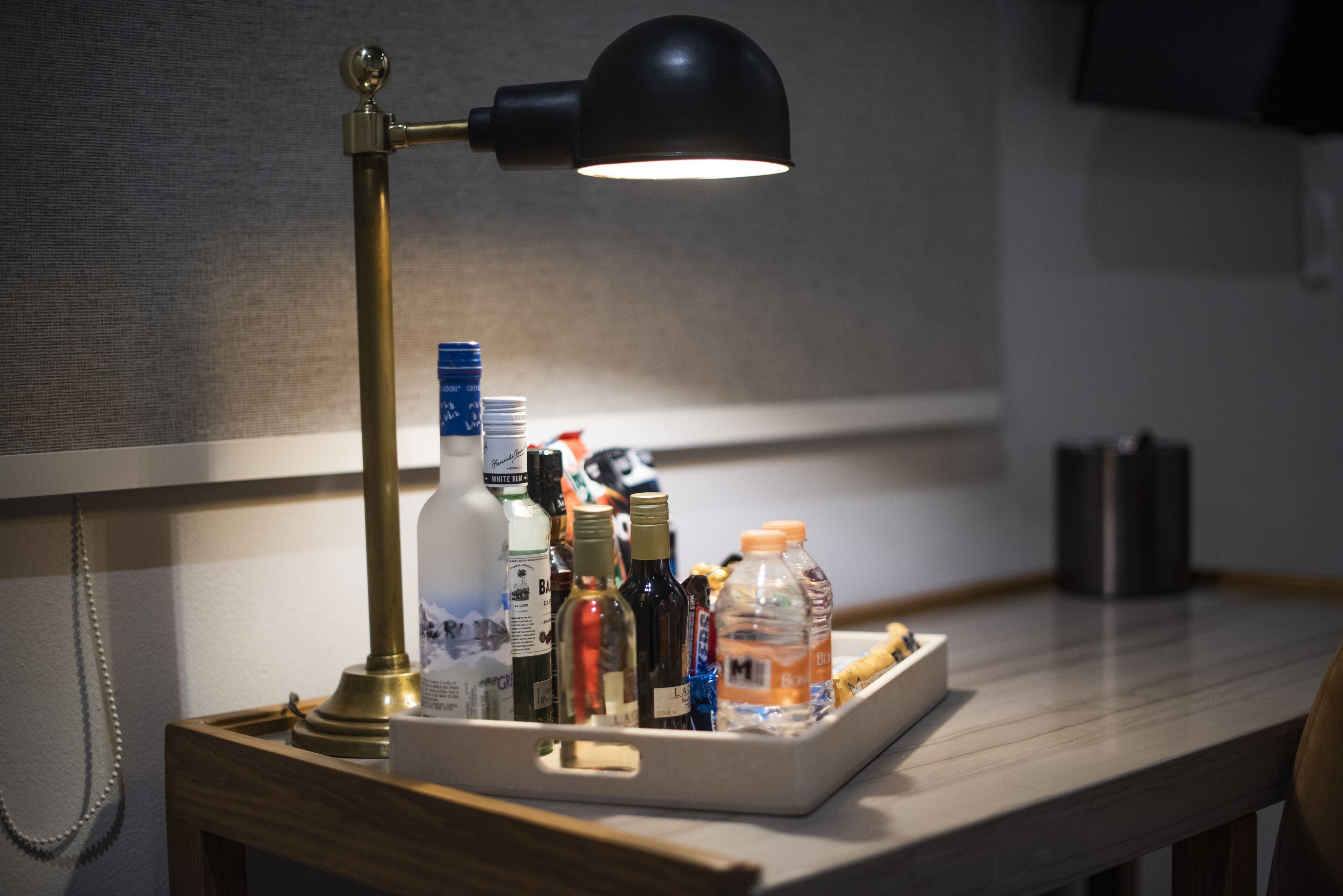 A tray with bottles and a lamp on a table.