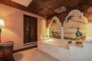 A bathroom with a large bathtub, a towel rack, and a decorative mural of a peacock and palm trees. - Anderson Ocean Club Condo🏖️ Beachfront 🏖️ (Myrtle Beach)