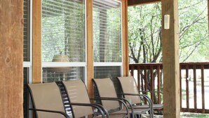 A covered porch with wooden flooring and metal chairs. - Mt. Shavano Chalet at Creekside chalets (Salida)