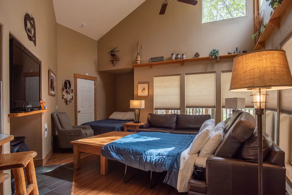 A cozy living room with a sofa, a coffee table, a TV, and a fireplace.