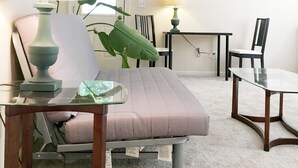 Une chambre à coucher comprenant un lit, un bureau, une chaise, une lampe et un ventilateur de plafond.