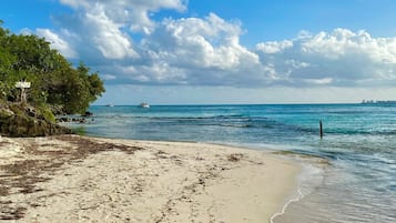 Ranta lähistöllä, aurinkotuoleja, rantapyyhkeitä