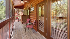 A wooden porch with a ceiling fan, two chairs, and a sign that reads "The Porch." - 2 BD Cabin near Branson Theatre District - Gas Fireplace & Whirlpool Tub,Ticket Discounts! (Branson)