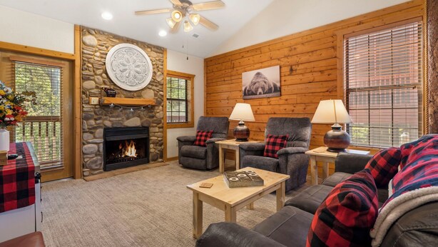 A cozy living room with a stone fireplace, two armchairs, a sofa, and a coffee table. - 2 BD Cabin near Branson Theatre District - Gas Fireplace & Whirlpool Tub,Ticket Discounts! (Branson)