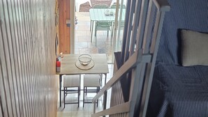 A staircase leading to a dining area with a table and chairs, a blue-striped sofa, and wooden paneling. - Air-conditioned, fully renovated duplex with private terrace (Lunel)