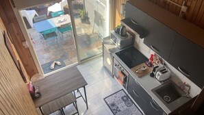 A kitchen with a dining area, a sliding glass door leading to an outdoor patio, and a small sink. - Air-conditioned, fully renovated duplex with private terrace (Lunel)