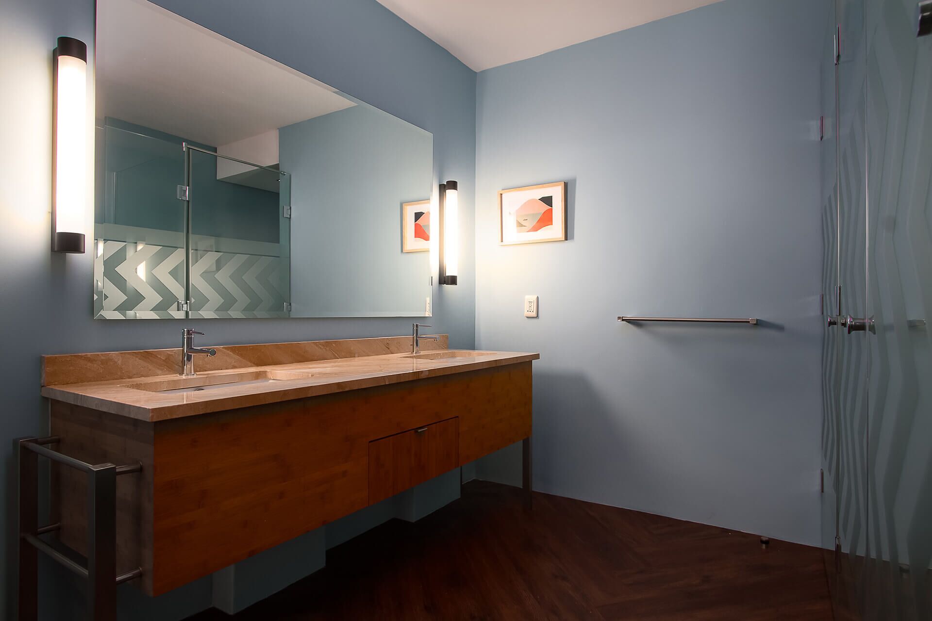 A bathroom with a wooden vanity, a large mirror, and a shower curtain.