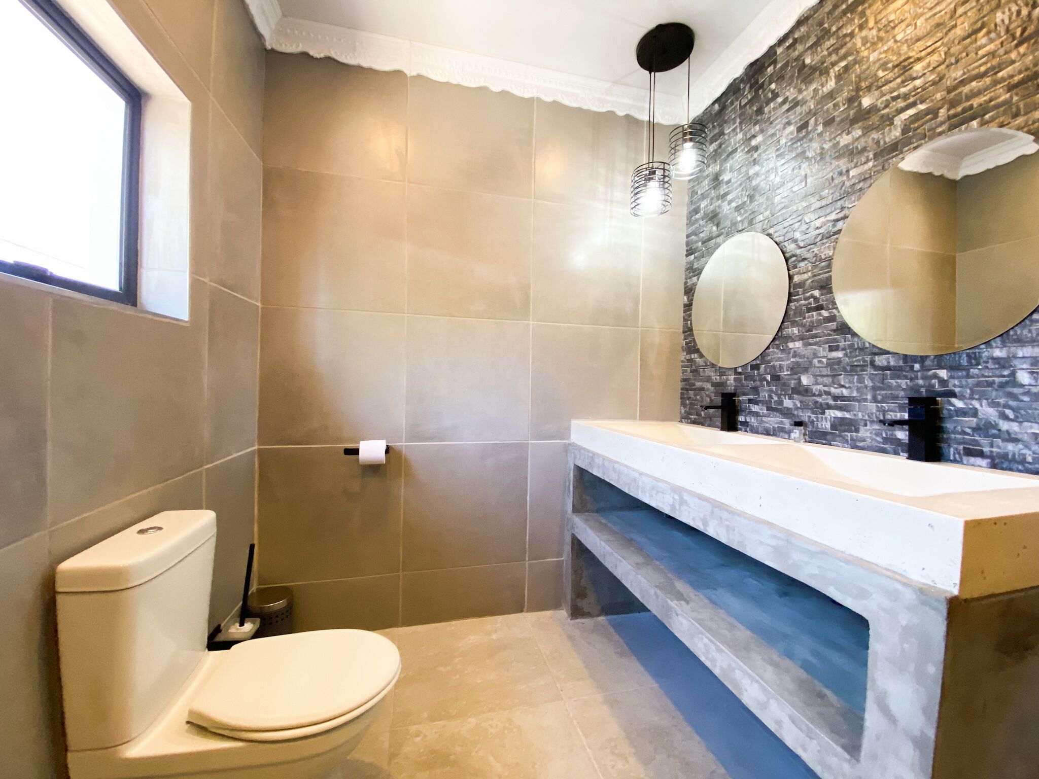 A bathroom with a toilet, a sink, and a mirror.