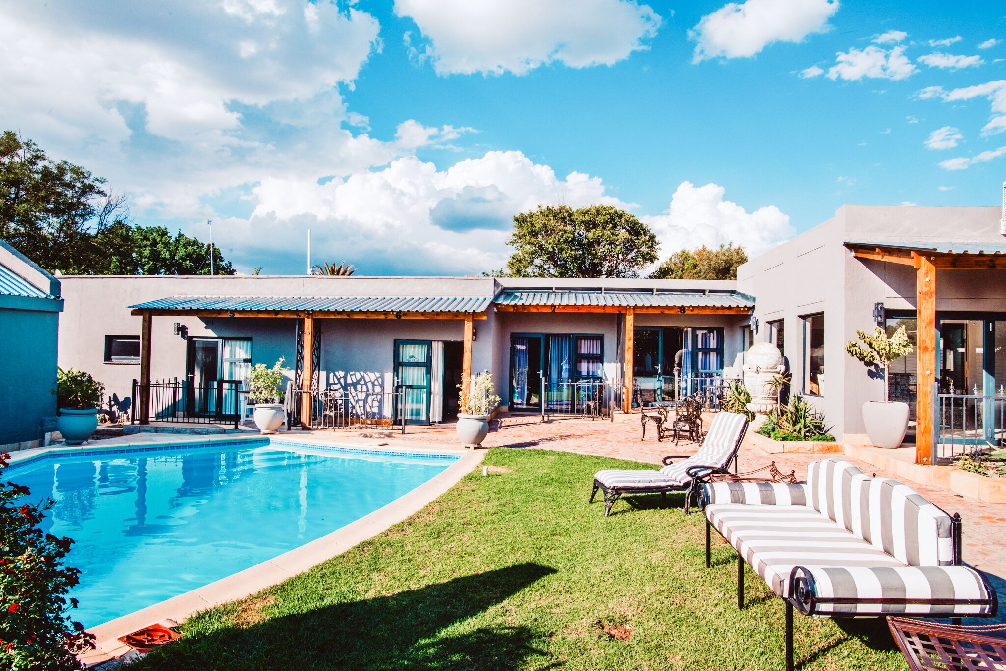 Una piscina al aire libre, sillones reclinables de piscina