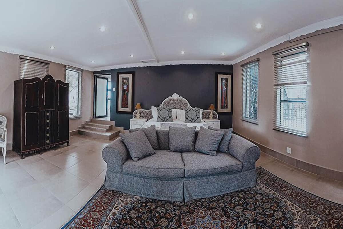 A living room with a grey sectional sofa, a dark wooden cabinet, and a patterned rug.