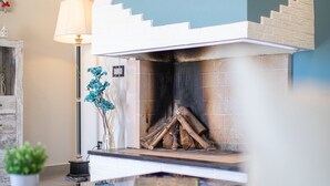 A modern living room with a fireplace, a lamp, and a small plant. - Sunset Bay Tecno Home Sardinia (Valledoria)