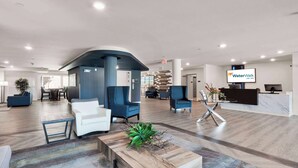 Un hall d’entrée spacieux, doté d’un comptoir d’accueil, de coins salon et d’un design moderne.